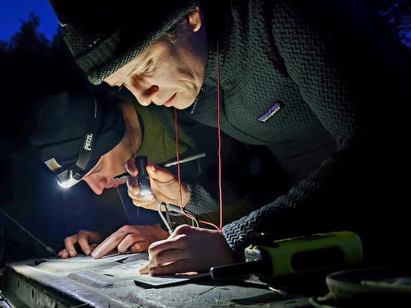 2 personen lezen met behulp van zaklampen een kaart