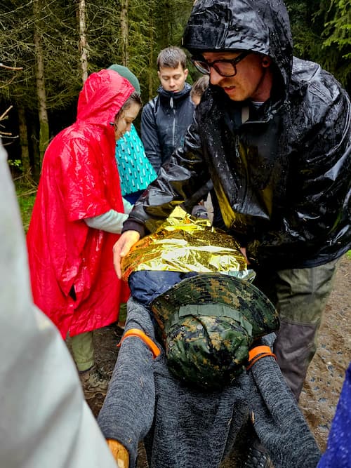 persoon, gewikkeld in warmte folie wordt gedragen op een gebouwde brancard