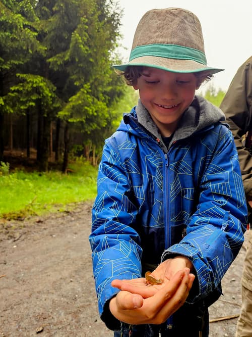 kind met een salamander op zijn hand